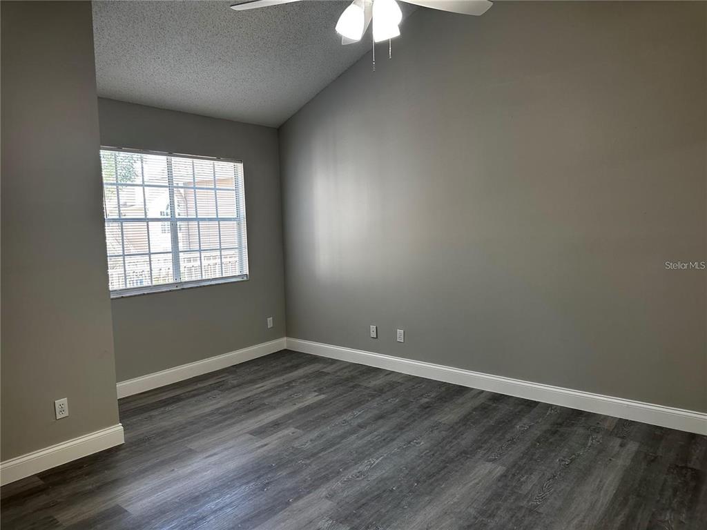 652 Roaring Drive, Unit 234 Altamonte Springs, FL 32714 - Photo 29 of 39 an empty room with wooden floor and windows