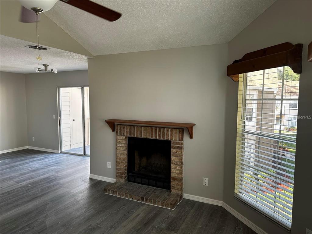 652 Roaring Drive, Unit 234 Altamonte Springs, FL 32714 - Photo 6 of 39 an empty room with wooden floor fireplace and windows