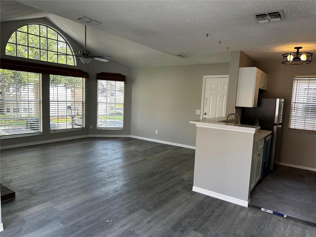 652 Roaring Drive, Unit 234 Altamonte Springs, FL 32714 - Photo 8 of 39 an empty room with wooden floor windows and entryway