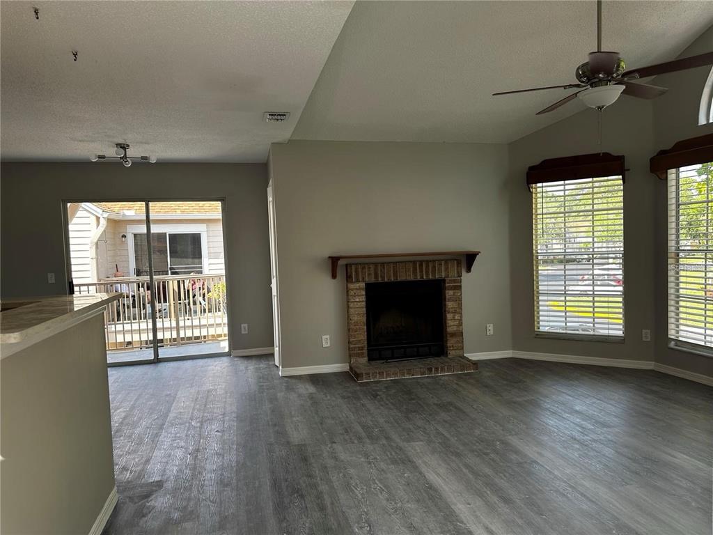652 Roaring Drive, Unit 234 Altamonte Springs, FL 32714 - Photo 9 of 39 wooden floor fireplace and windows in an empty room