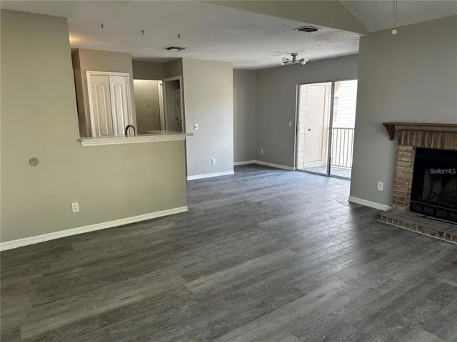 an empty room with wooden floor and fireplace