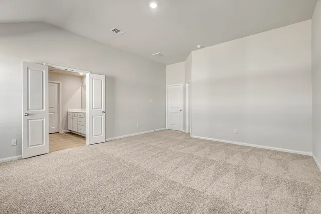 a kitchen with stainless steel appliances granite countertop white cabinets a sink a stove a refrigerator and microwave with wooden floor