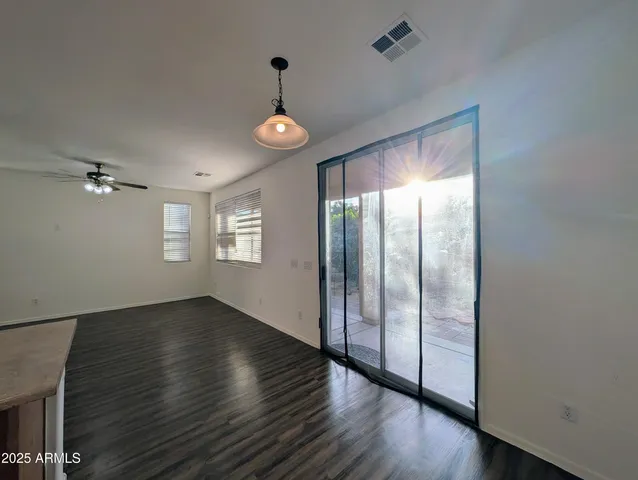 a kitchen with stainless steel appliances granite countertop a stove top oven a sink with white cabinets and wooden floor