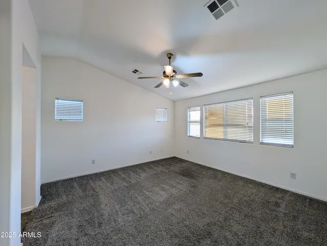 an empty room with windows and fan