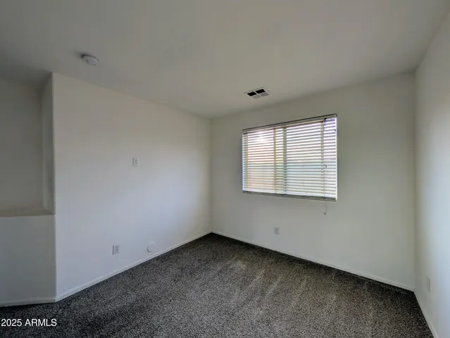 an empty room with closet and a ceiling fan