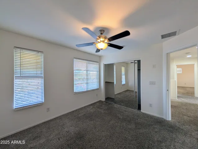 a backyard of a house with wooden fence and a lawn chairs