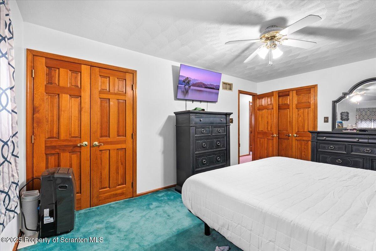 211 New Street Duryea, PA 18642 - Photo 14 of 32 a bedroom with a large bed and a chandelier