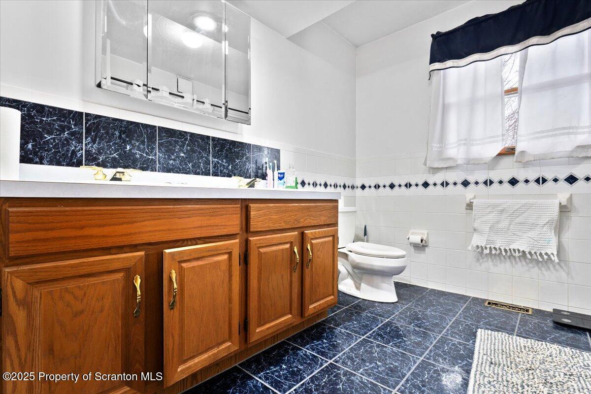 211 New Street Duryea, PA 18642 - Photo 20 of 32 a bathroom with a toilet a sink and a mirror