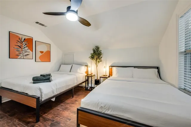 a bedroom with beds and a chandelier