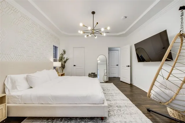 a bedroom with a large bed and a flat screen tv