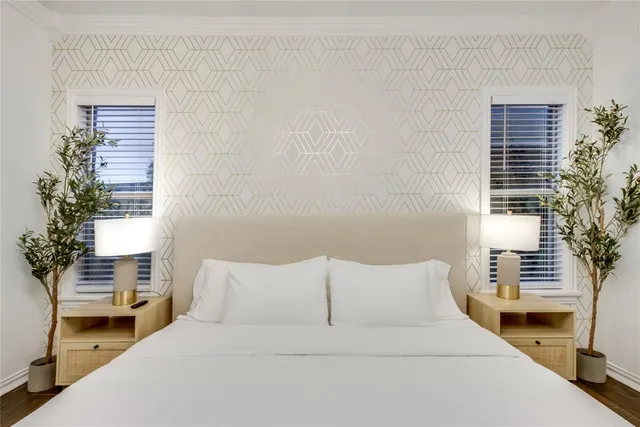 a large bed sitting in a bedroom next to a window