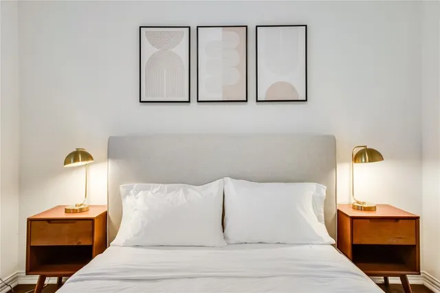 a large bed sitting in a bedroom next to a lamp