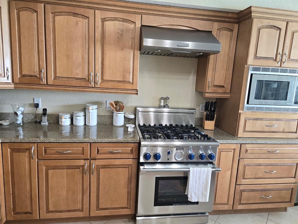 650 Golden Gate Point, Unit 301 Sarasota, FL 34236 - Photo 12 of 31 a kitchen with granite countertop white cabinets and stainless steel appliances
