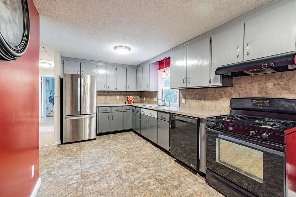 83 Mallowhill Road Springfield, MA 01129 - Photo 14 of 38 a kitchen with granite countertop a stove top oven a sink and a refrigerator