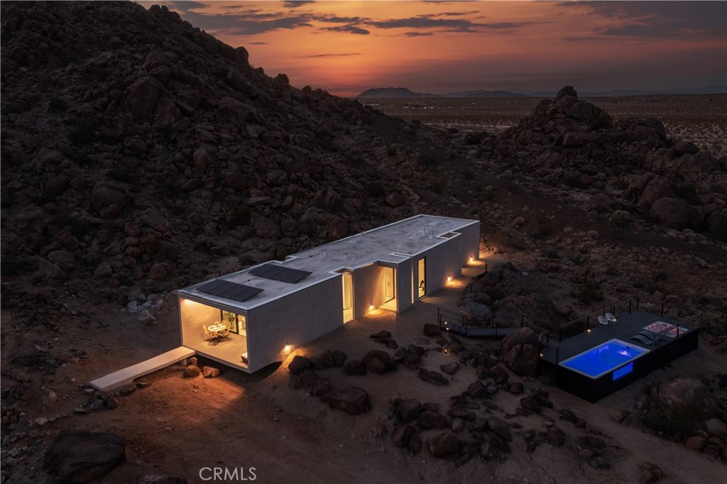 1824 Mountain Shadow Road Joshua Tree, CA 92252 - Photo 38 of 39 a backyard of a house with table and chairs & wooden floor