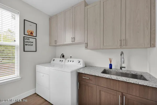 a kitchen with stainless steel appliances granite countertop white cabinets sink and window