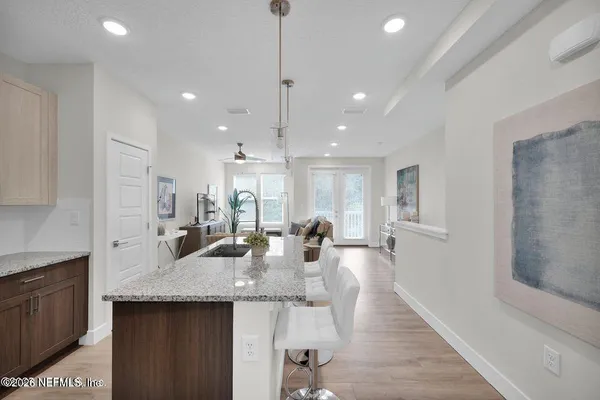 a kitchen with granite countertop kitchen island a sink appliances and a counter top space