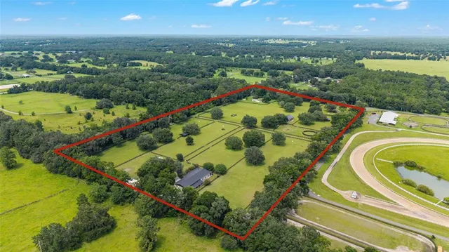 an aerial view of a residential houses with outdoor space and a lake view