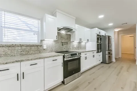 a kitchen with stainless steel appliances granite countertop a stove and a sink