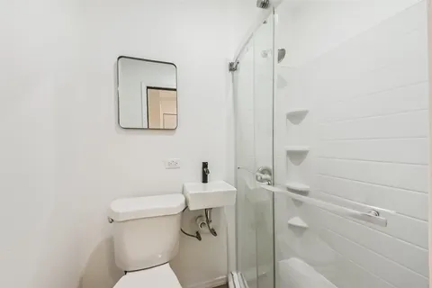 a bathroom with a toilet and a shower