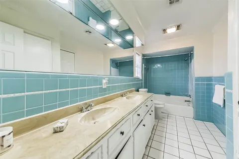 a spacious bathroom with a tub sink and a mirror
