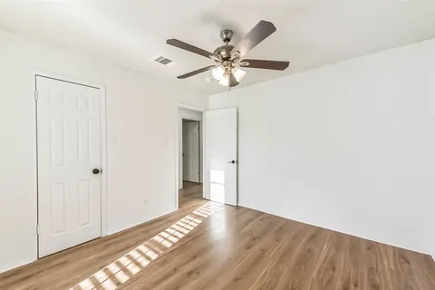 a view of a livingroom with wooden floor and a ceiling fan