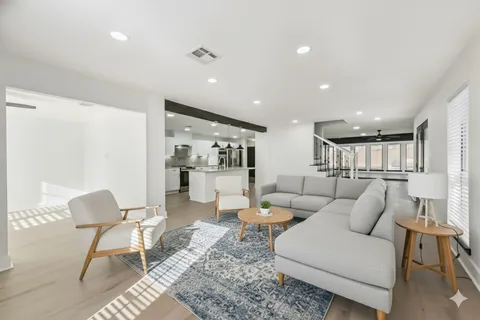 a living room with furniture and a view of kitchen