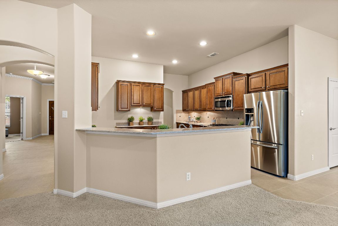 3948 Sapphire Loop Round Rock, TX 78681 - Photo 17 of 40 a kitchen with stainless steel appliances granite countertop a refrigerator and a stove top oven