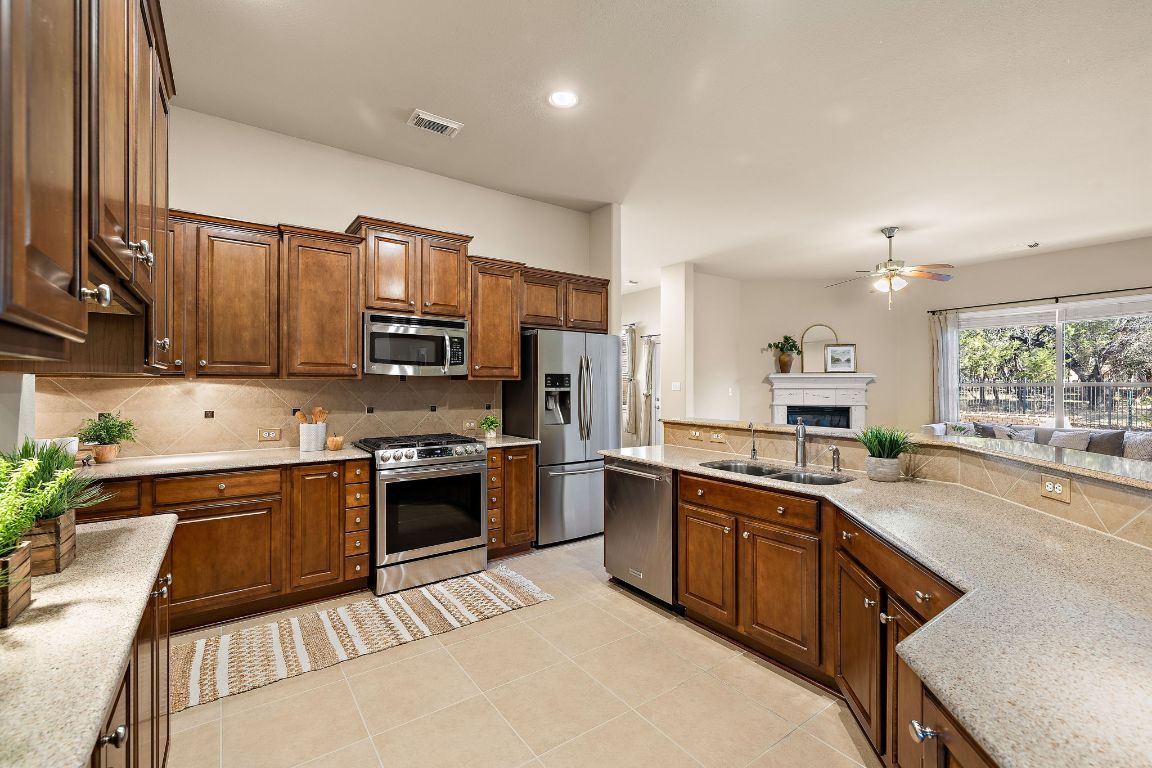 3948 Sapphire Loop Round Rock, TX 78681 - Photo 19 of 40 a kitchen with stainless steel appliances granite countertop a sink stove and refrigerator