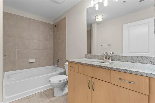 a bathroom with a granite countertop sink a toilet and bathtub