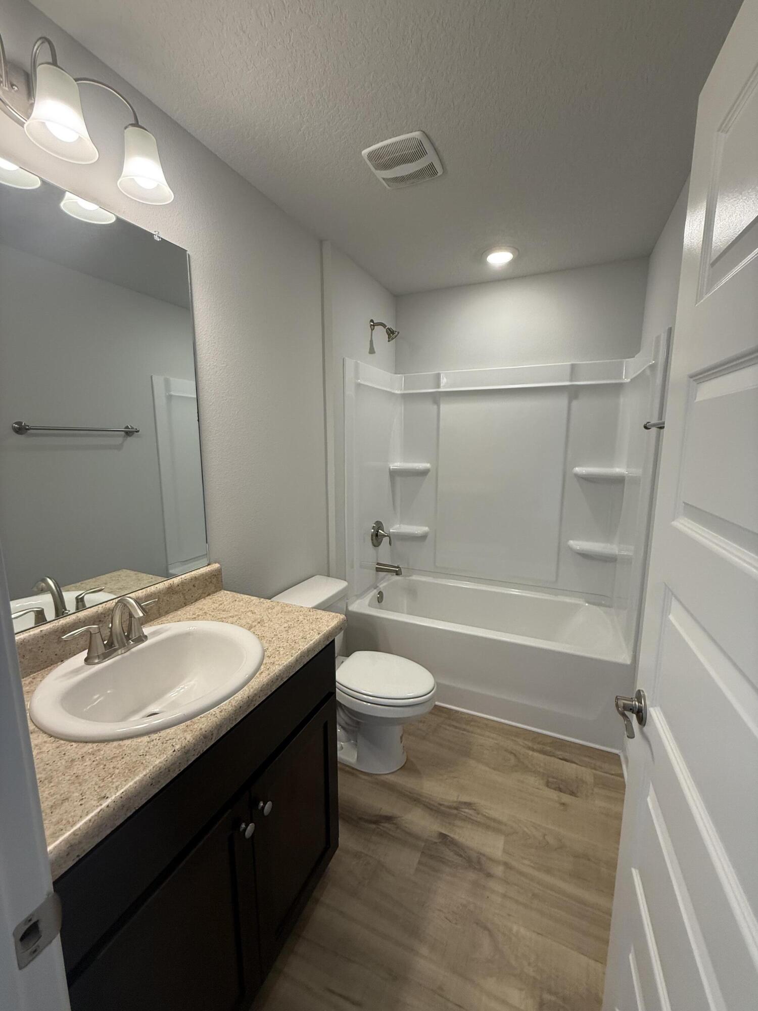 6000 Crocket Cove Crestview, FL 32539 - Photo 12 of 20 a bathroom with a granite countertop sink toilet a mirror and shower