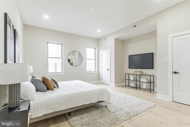 a bedroom with bed and a flat screen tv