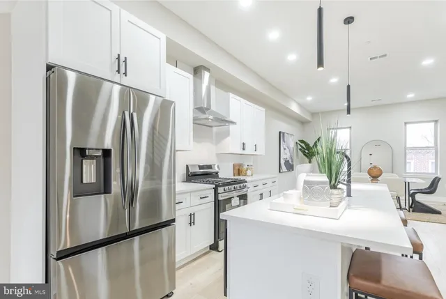 a kitchen with stainless steel appliances a refrigerator sink and cabinets
