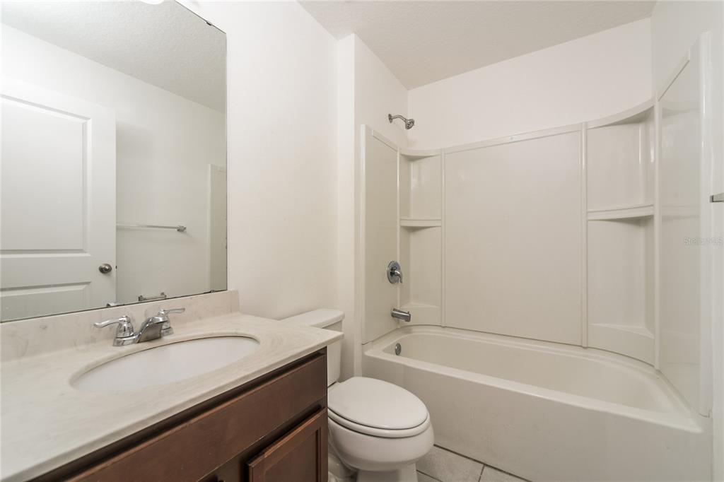 1477 Lucerne Loop Road Northeast Winter Haven, FL 33881 - Photo 14 of 15 a bathroom with a granite countertop sink toilet and shower