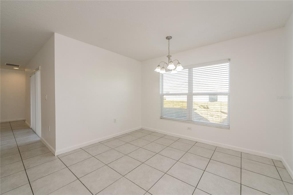 1477 Lucerne Loop Road Northeast Winter Haven, FL 33881 - Photo 8 of 15 an empty room with chandelier fan and window