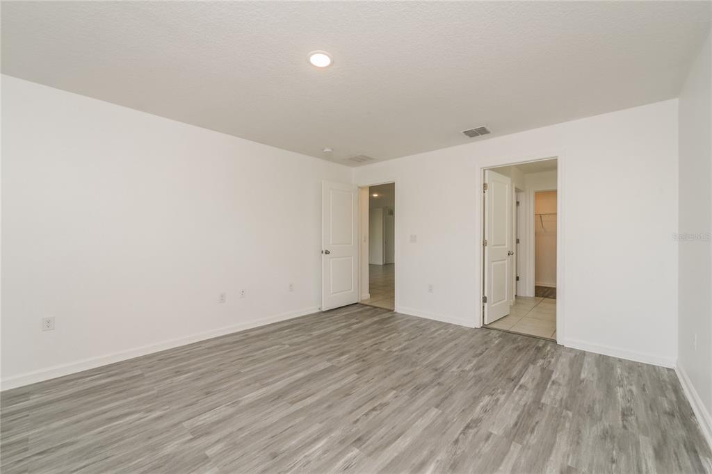 1477 Lucerne Loop Road Northeast Winter Haven, FL 33881 - Photo 10 of 15 a view of an empty room with wooden floor