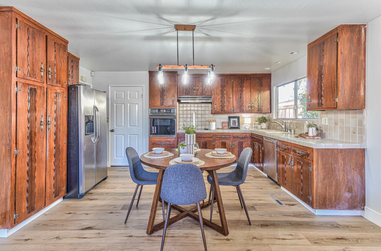 242 Howes Drive Los Gatos, CA 95032 - Photo 11 of 37 a kitchen with a refrigerator a sink dishwasher a dining table and chairs with wooden floor