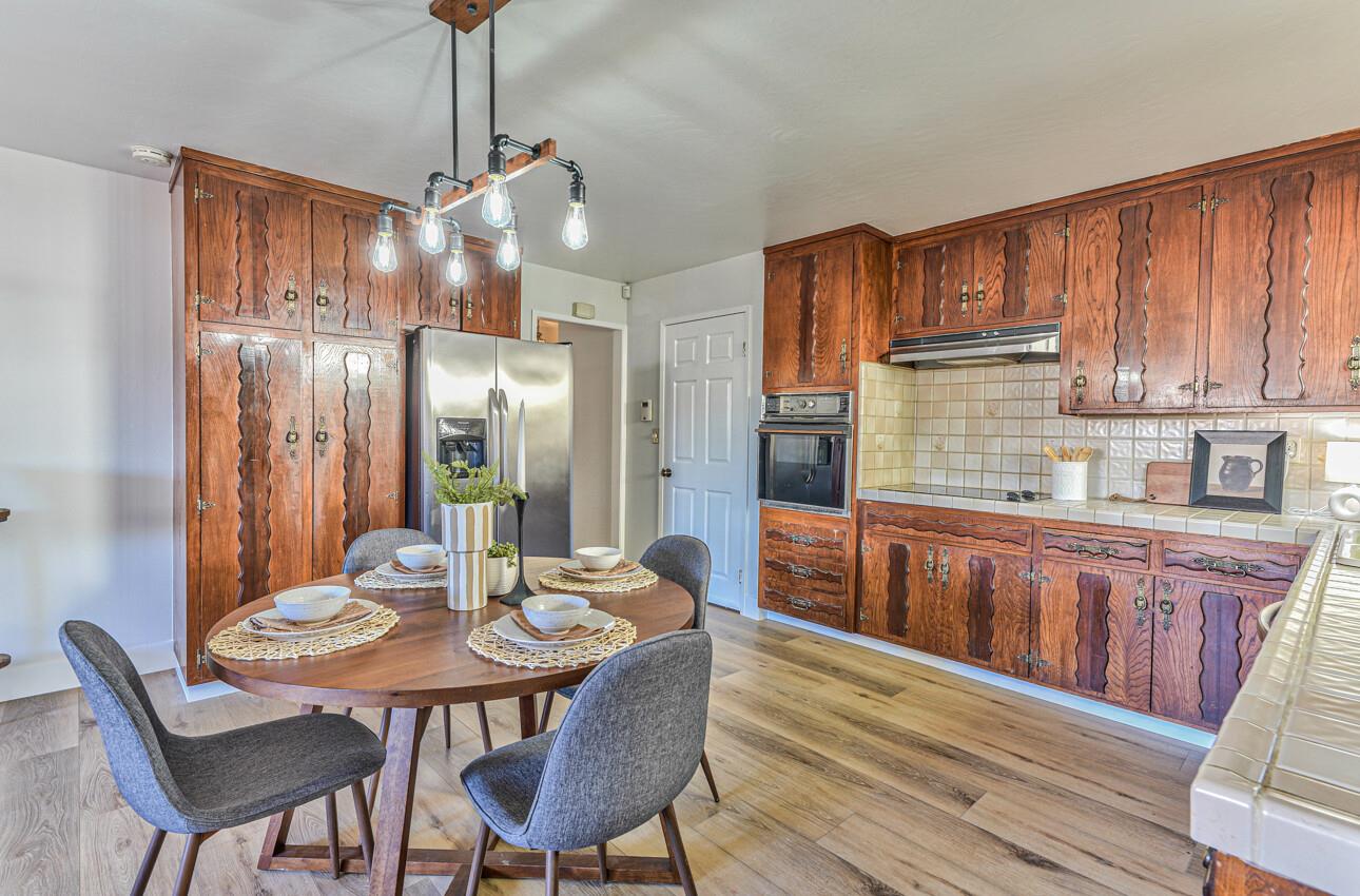 242 Howes Drive Los Gatos, CA 95032 - Photo 12 of 37 a kitchen with granite countertop a dining table chairs and wooden cabinets