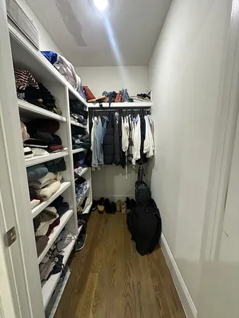a view of walk in closet with clothes and shoes