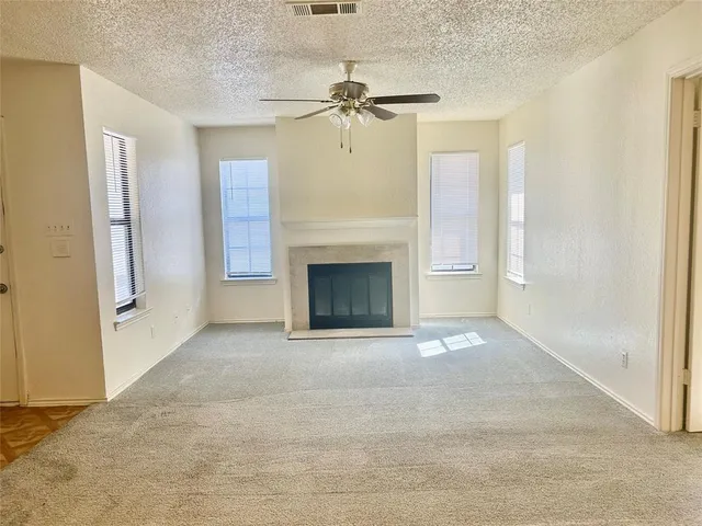 a view of an empty room with a fireplace and a window