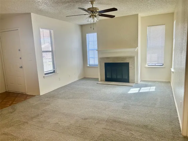an empty room with windows and fireplace
