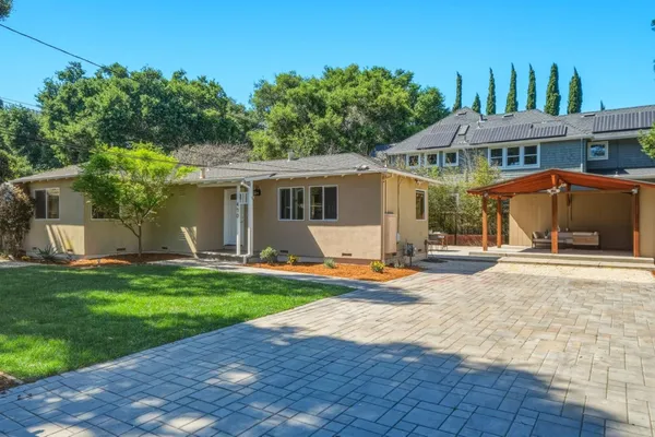 a front view of a house with yard and green space