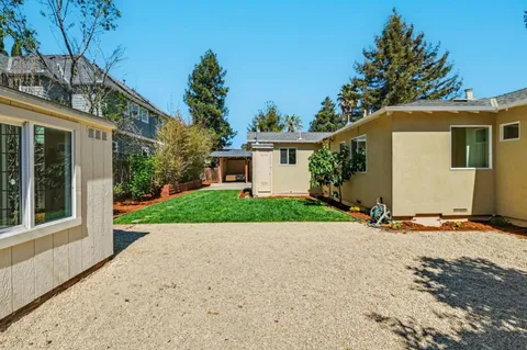 a view of a house with a yard and tree s