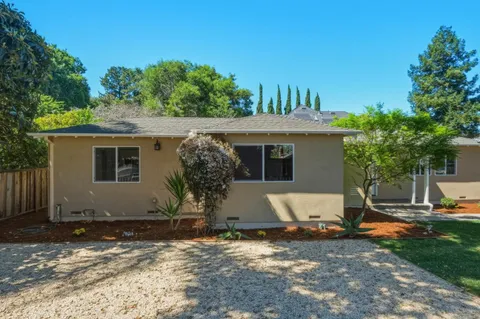 a front view of a house with yard and green space