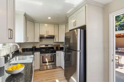 a kitchen with stainless steel appliances granite countertop a refrigerator a stove a sink and a microwave