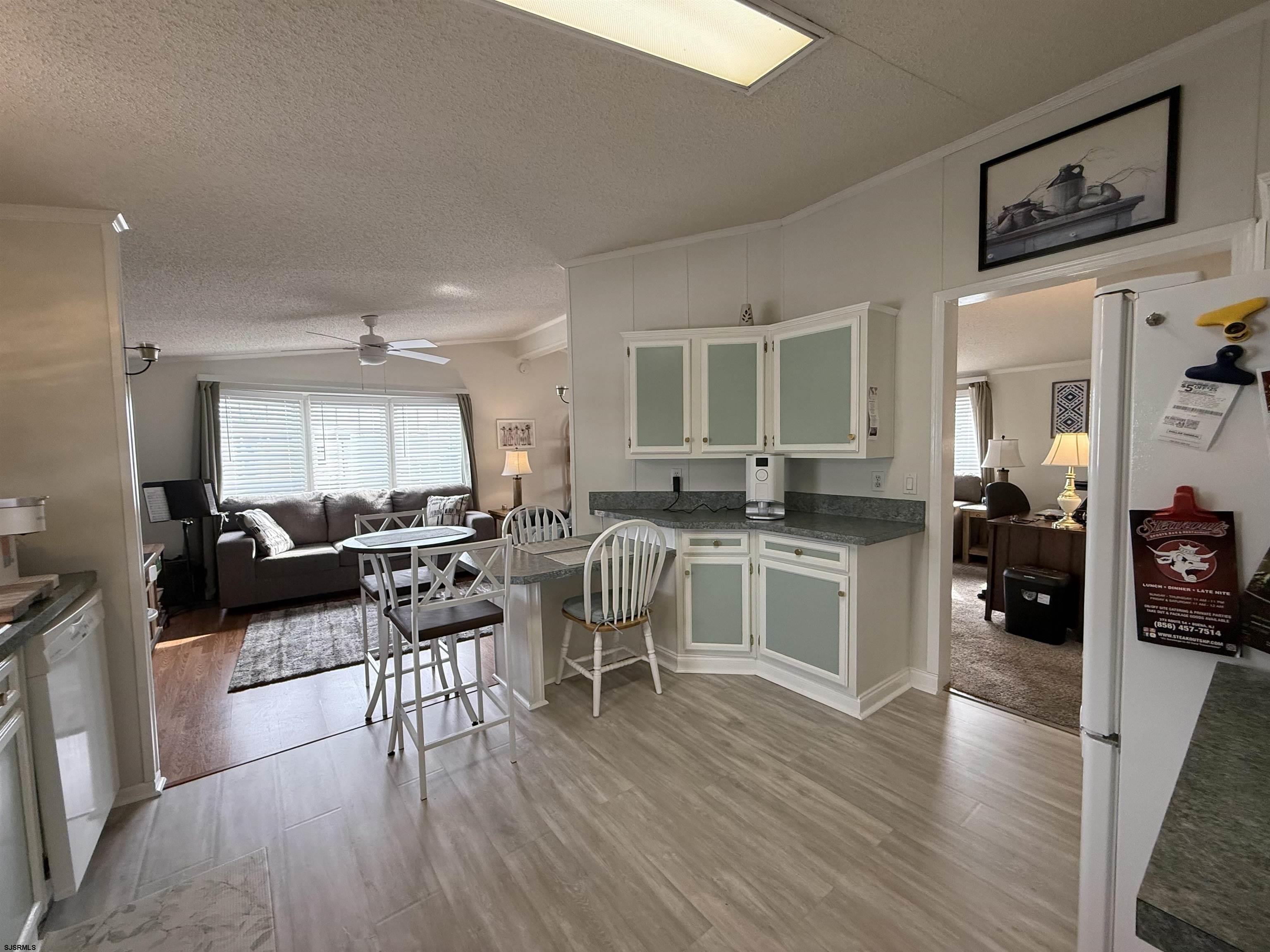 141 Country Lane Buena, NJ 08310 - Photo 5 of 24 a open kitchen with stainless steel appliances granite countertop a stove top oven a sink a dining table and chairs with wooden floor