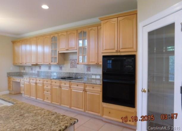 10004 Paradise Ridge Road, Unit 68 Charlotte, NC 28277 - Photo 9 of 24 a kitchen with granite countertop wooden cabinets and granite counter tops
