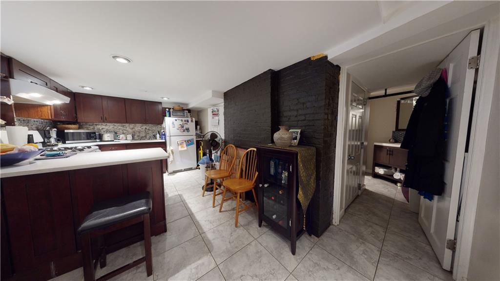 3216 Glenwood Road Brooklyn, NY 11210 - Photo 28 of 50 a kitchen with stainless steel appliances kitchen island granite countertop a refrigerator and a sink