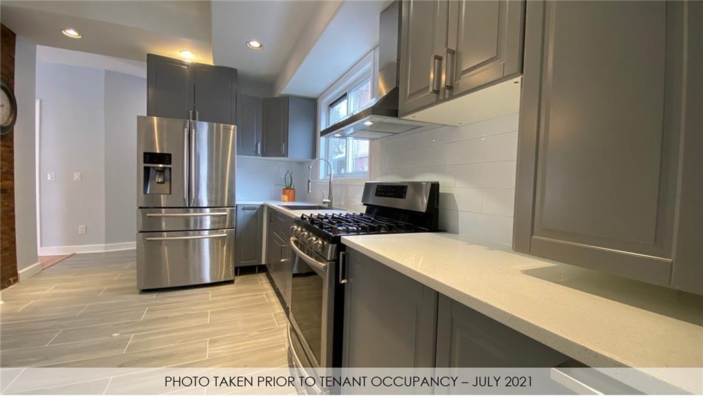 3216 Glenwood Road Brooklyn, NY 11210 - Photo 42 of 50 a kitchen with stainless steel appliances kitchen island granite countertop a refrigerator and a stove