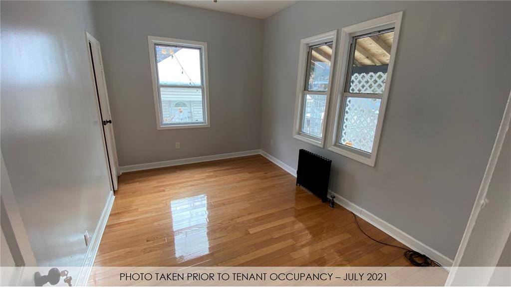 3216 Glenwood Road Brooklyn, NY 11210 - Photo 45 of 50 a view of an empty room with wooden floor and a window